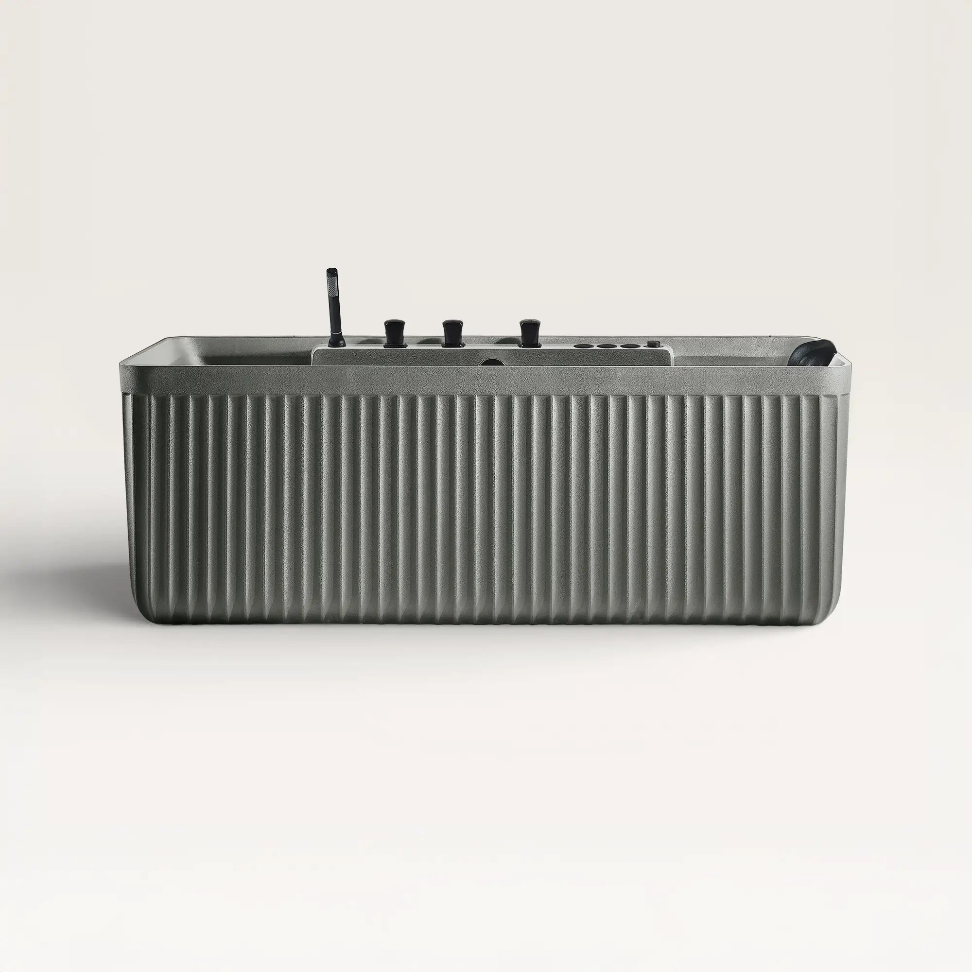 Front view of the Kolpa Spa bath with black tapware in cement-grey
