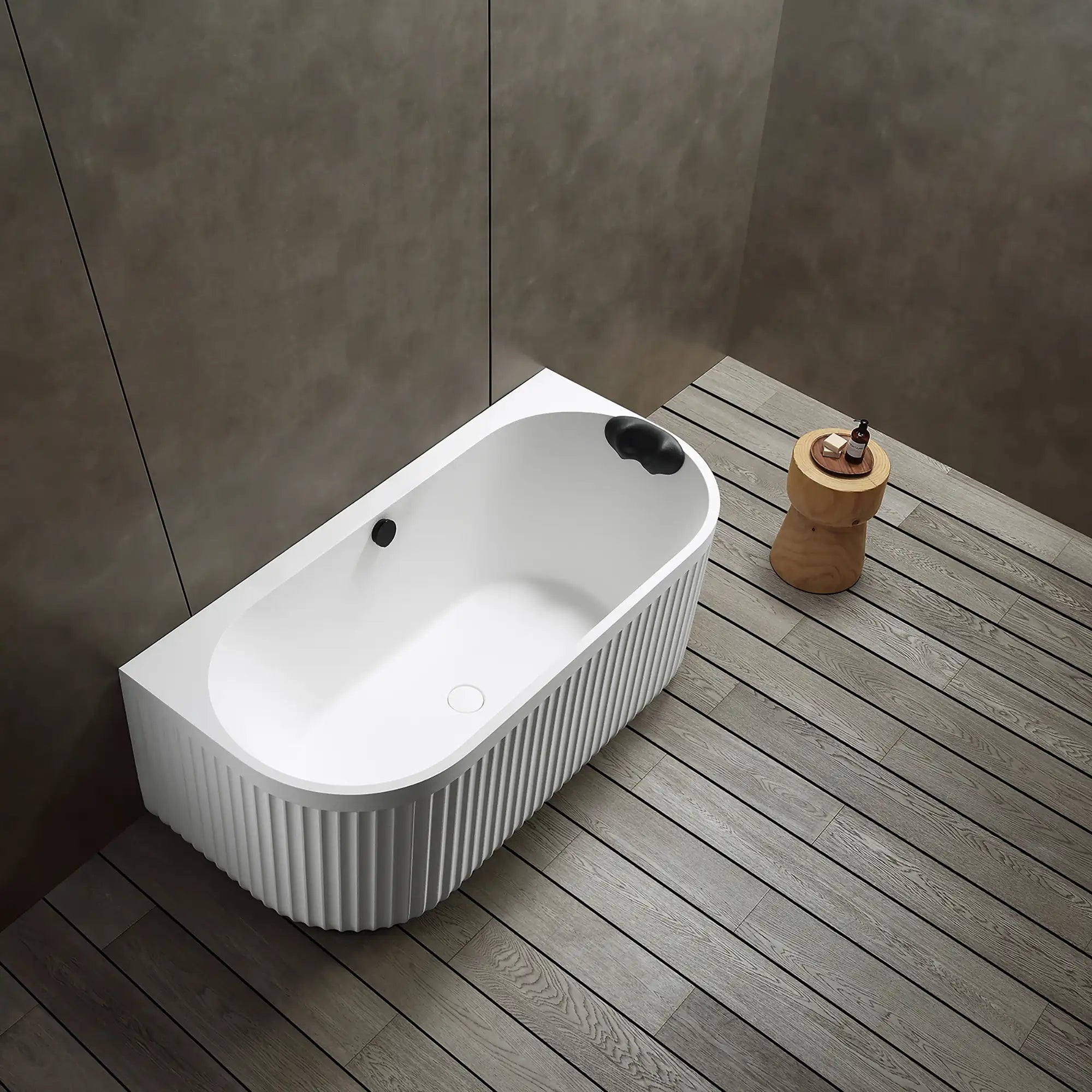 A top view of the Doria back-to-wall bathtub in white, in a modern bathroom with wooden floor and gray walls.