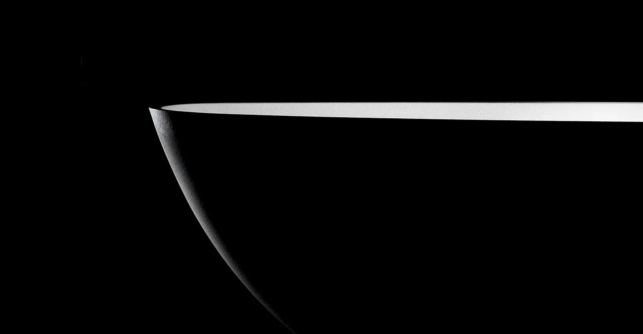 A close-up of the Aria bathtub in black and white, on a black background.