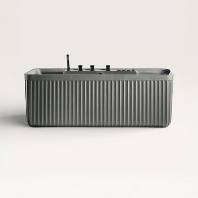 Front view of the Kolpa Spa bath with black tapware in cement-grey
