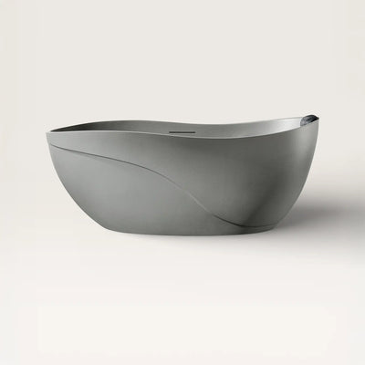 Front view of the Soma freestanding bath in cement-grey with a black magnetic pillow