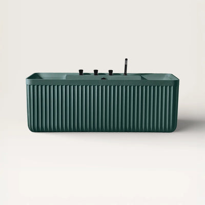 Front view of the Kolpa back-to wall bath with black tapware in green