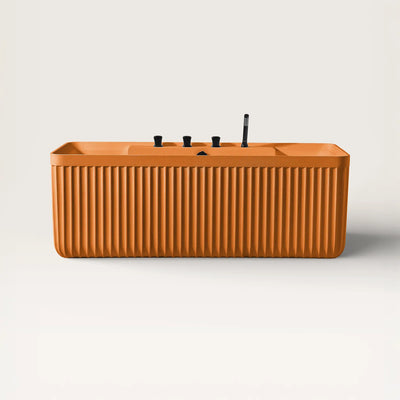 Front view of the Kolpa back-to wall bath with black tapware in orange