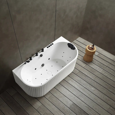 A top view of the Doria back-to-wall with faucet bathtub in white with black tapware, in a modern bathroom with wooden floor and gray walls.