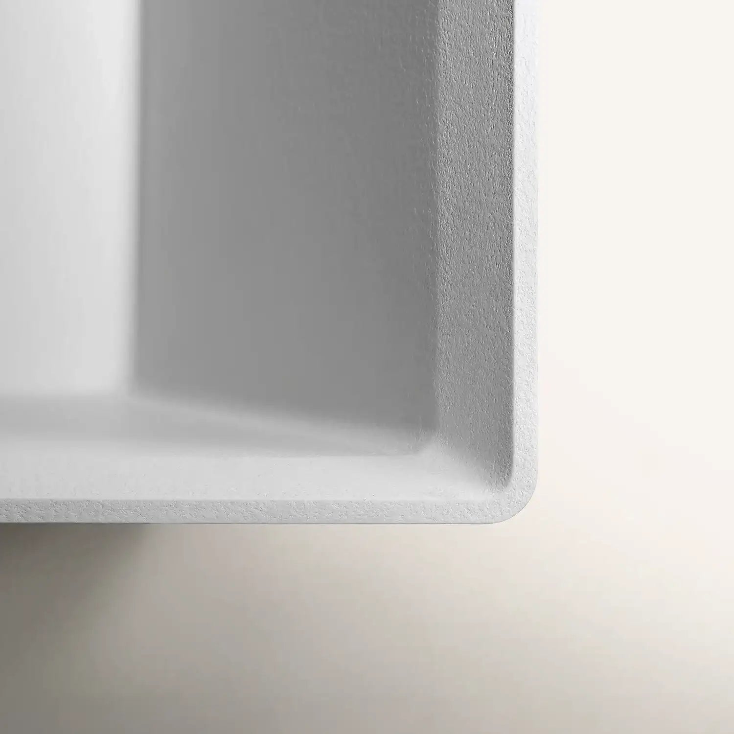 Close up of the pop-up waste of a Bellastone bath in white colour, showing the disctinct texture of the material