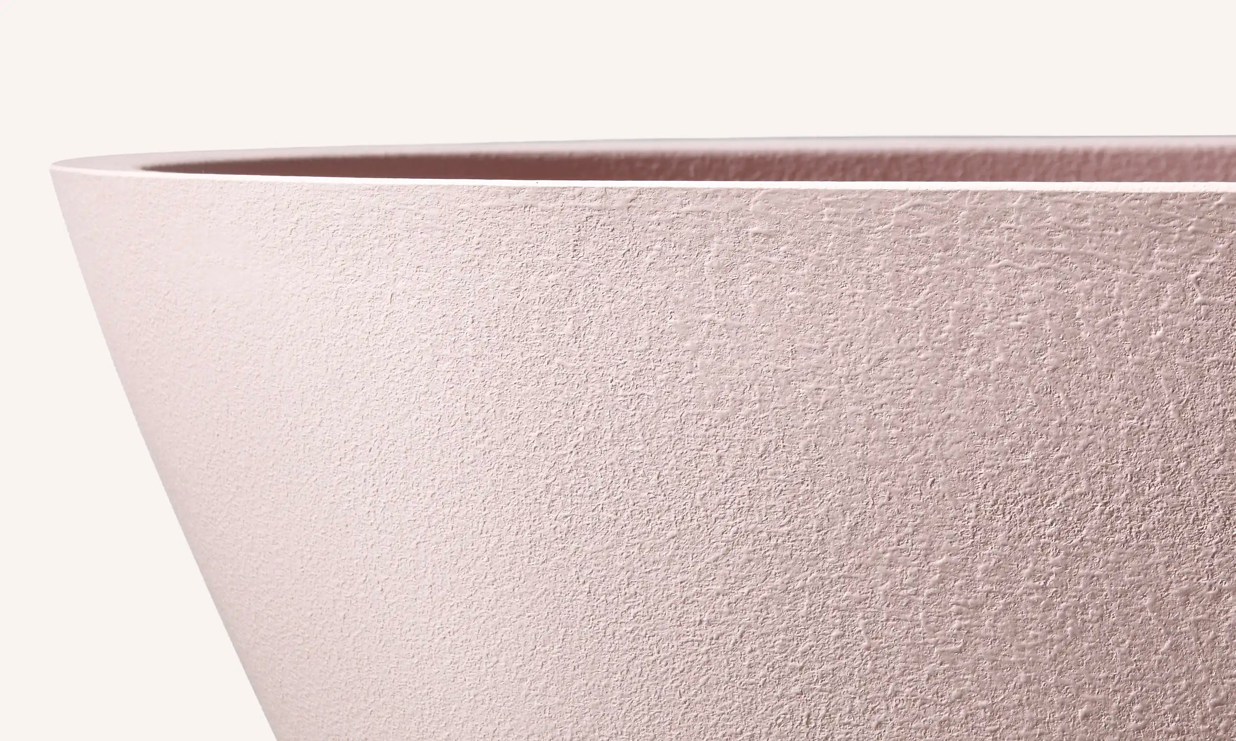 Close up of the pop-up waste of a Bellastone bath in pink colour, showing the disctinct texture of the material